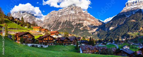 Switzerland nature and travel. Alpine scenery. Scenic traditional mountain village Grindelwald surrounded by snow peaks of Alps. Popular tourist destination and ski resort photo