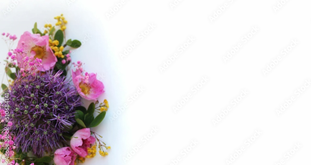 A bouquet with a purple decorative bow on a white background. Flower arrangement. Background for a greeting card. A bouquet with a purple decorative bow on a white background. Flower arrangement. Background for a greeting card.