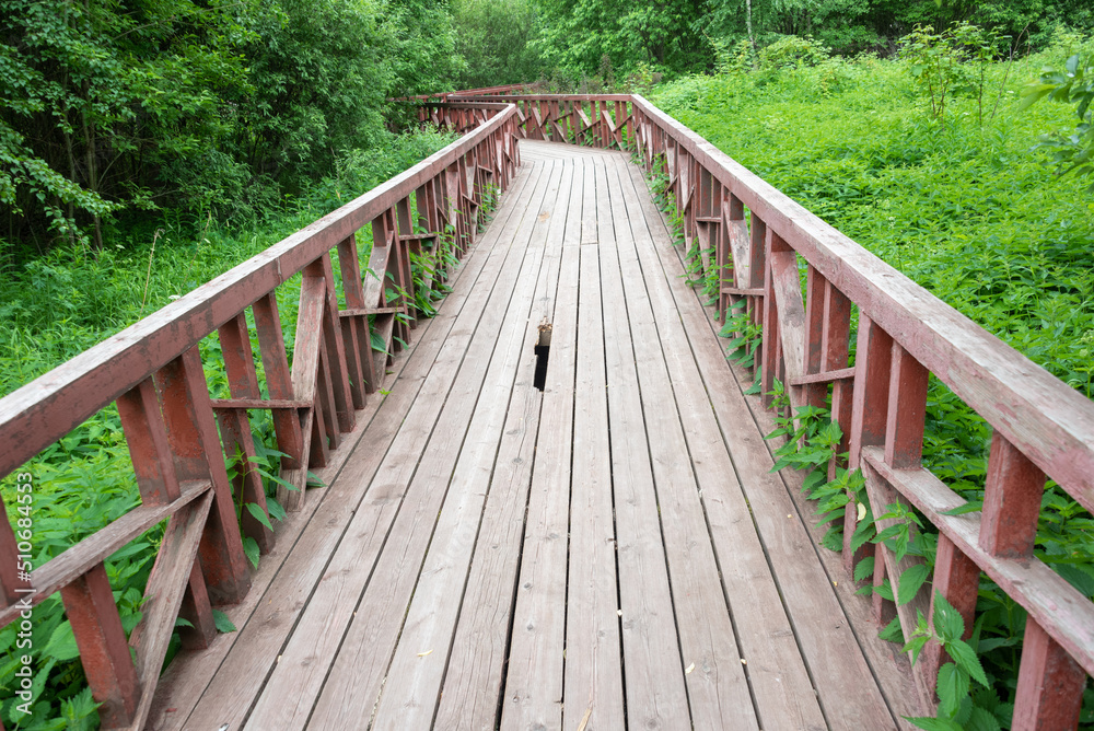 Obraz premium Wooden ecological path with a hole in the deck.