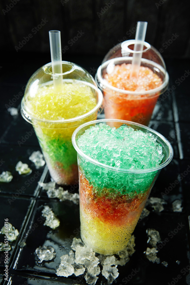 Fototapeta premium Three colorful slush drinks on black background