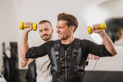 Man Doing EMS Workout With Coach In The Gym photo