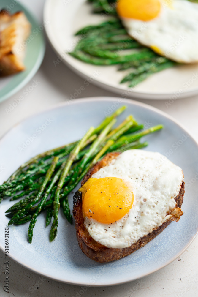 Fried eggs with toasted bread and green asparagus. Fast lunch ideas, healthy breakfast, summer food. Fried eggs with toasted bread and green asparagus. Fast lunch ideas, healthy breakfast, summer food.