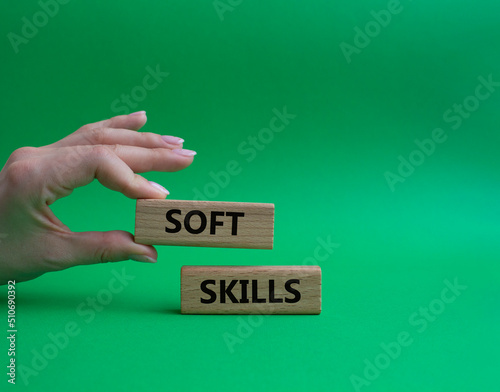 Soft skills symbol. Wooden blocks with words Soft skills. Beautiful green background. Businessman hand. Business and Soft skills concept. Copy space.