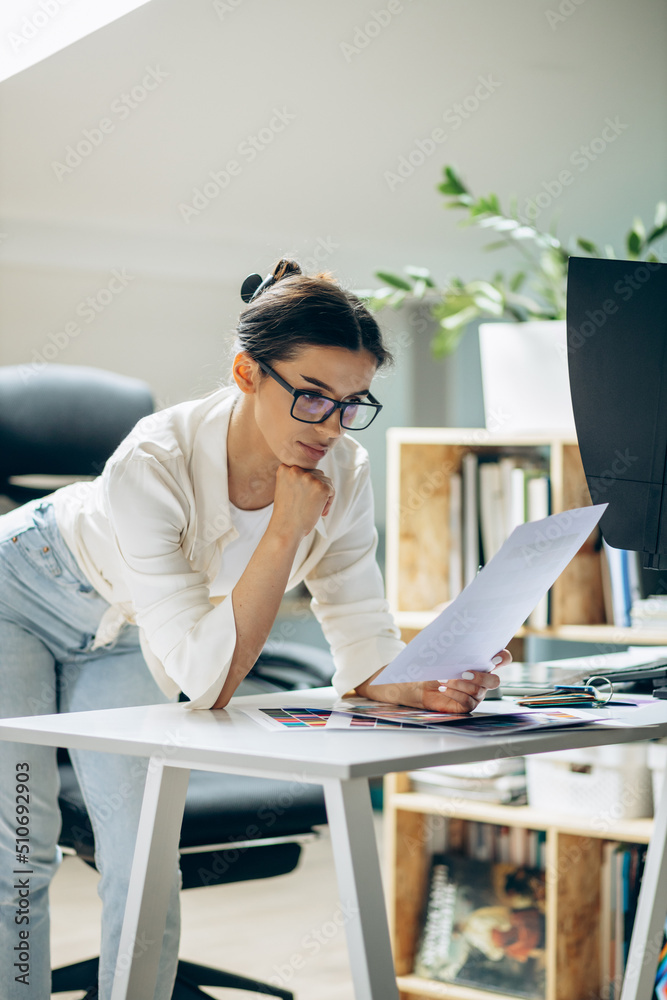 Female digital designer looking at swatches at an office Female digital designer looking at swatches at an office