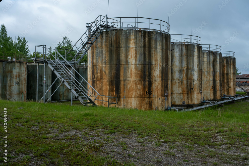 Train tracks through an industrial area. old oil storage tanks. oil exports have stalled. Train tracks through an industrial area. old oil storage tanks. oil exports have stalled.