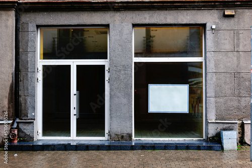 Facade of a boutique with a large window and a place for a name. Empty showcase.