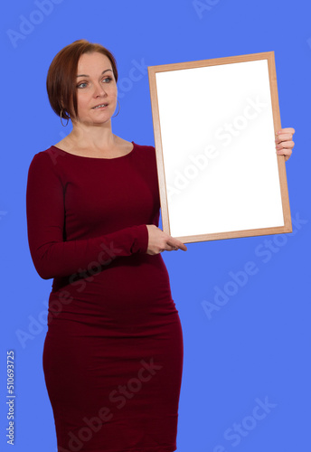 woman in red dress holding empty board on blue background