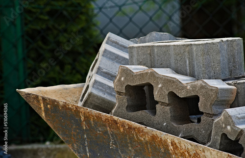 Kostki brukowe , ażurowe ( betonowe bloczki z dziurkami ) , przeznaczone do brukowania podjazdu , złożone w taczce .