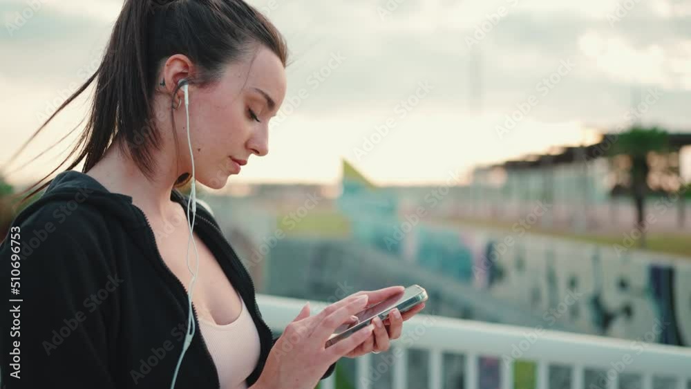 Young woman with freckles and long ponytail wearing black hoodie and