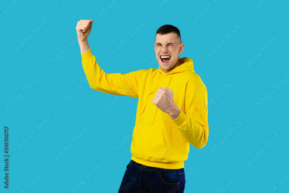 Emotional Man Shaking Fists Shouting Celebrating Victory On Blue Background Emotional Man Shaking Fists Shouting Celebrating Victory On Blue Background