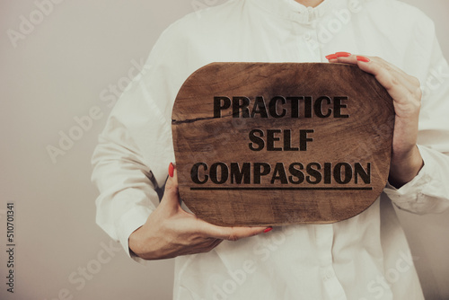 Practice self compassion inspirational text on wooden board photo