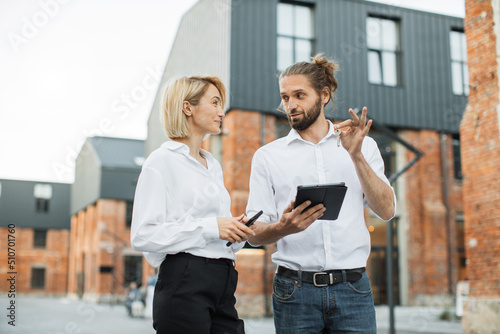Happy smiling business woman taking key of future new apartment. Professional real estate agent wearing white shirt holding in hand and giving keys to young buyer. Mortgage  Property For Sale Concept