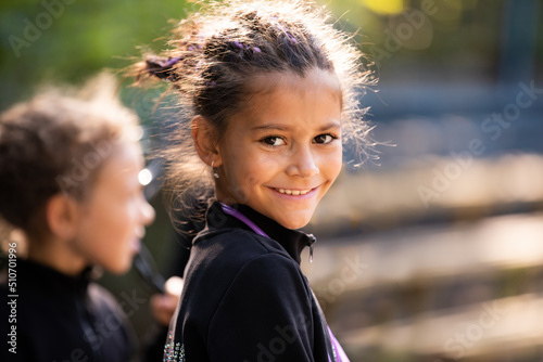 Portrait of smiling girl trainee on rhythmic gymnastics training in summer in sports camp outdoors