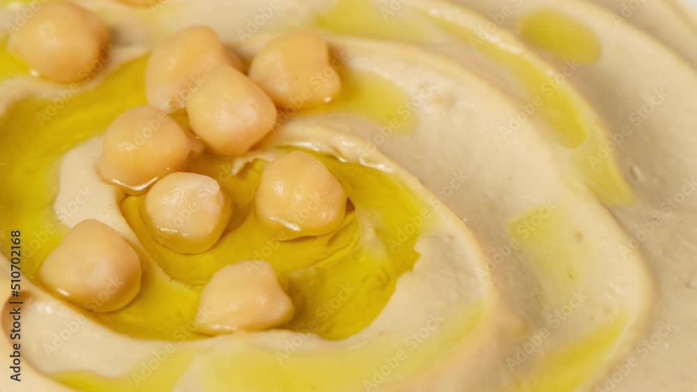 Chickpea hummus close up. Bowl of homemade natural organic hummus garnished with chickpeas, olive oil, spices. Hummus or fava, a hearty snack of legumes. Lean, vegetarian dish rotation close-up Chickpea hummus close up. Bowl of homemade natural organic hummus garnished with chickpeas, olive oil, spices. Hummus or fava, a hearty snack of legumes. Lean, vegetarian dish rotation close-up
