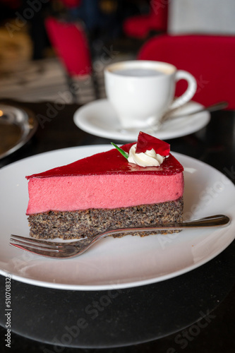 Fototapeta Naklejka Na Ścianę i Meble -  Piece of famous Poppy seed cake with raspberry mousse of Austrian origin served with whipped cream and cup of coffee