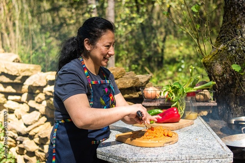 Farmer woman cooking outdoors in nature happily