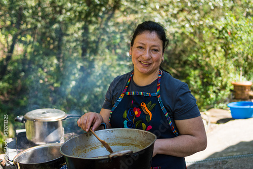 Farmer woman cooking outdoors in nature happily