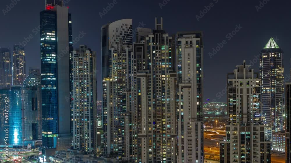 Bay Avenue with modern towers residential development in Business Bay aerial night timelapse, Dubai, UAE. Skyscrapers with glowing windows Bay Avenue with modern towers residential development in Business Bay aerial night timelapse, Dubai, UAE. Skyscrapers with glowing windows