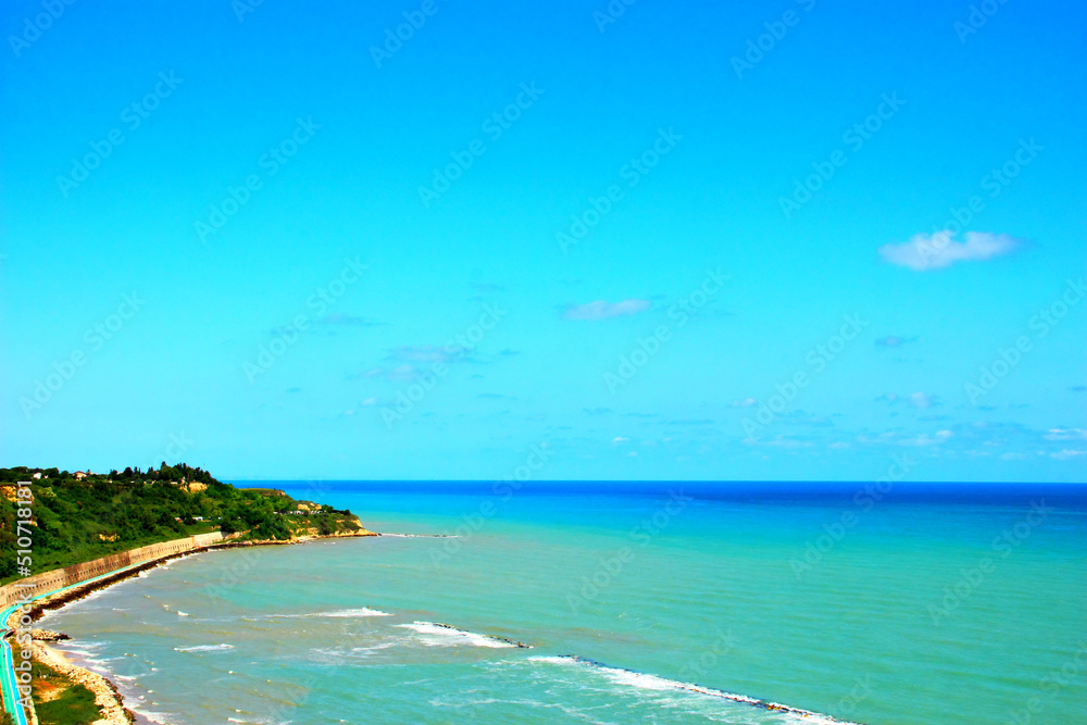 Summery scenery in Ortona with green vegetation on the Adriatic Coastline and serene blue sea peacefully washing its shores on a fine sunny day