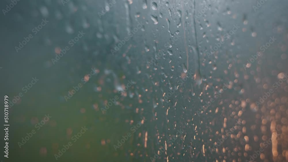 Drops of water on the glass transparent window with colored lights