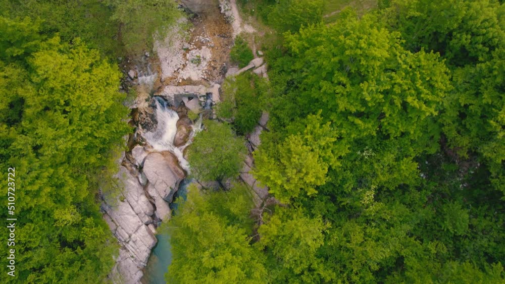 scenic drone shot of a small waterfall on stones surrounded by the forest. High quality 4k footage scenic drone shot of a small waterfall on stones surrounded by the forest. High quality 4k footage