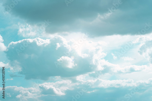 White clouds and sun rays in a blue sky.Beautiful heavenly wallpaper in blue tones. Heaven background.