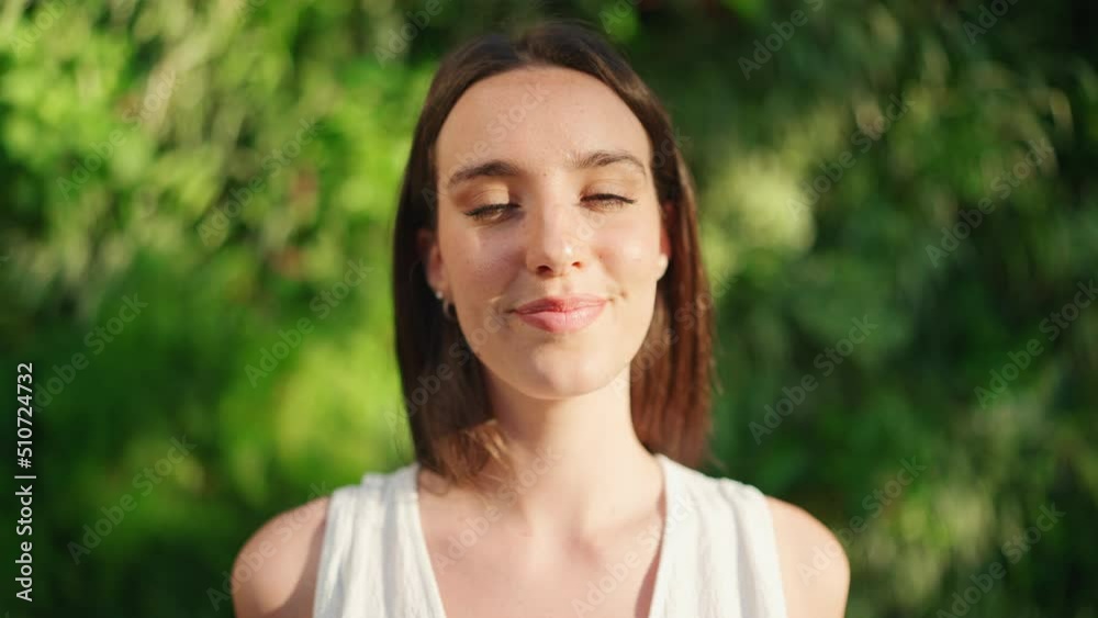 Young woman with freckles and dark loose hair wearing white top and jeans looks at the camera and smiles. Beautiful girl with long eyelashes smiling broadly at the camera Young woman with freckles and dark loose hair wearing white top and jeans looks at the camera and smiles. Beautiful girl with long eyelashes smiling broadly at the camera
