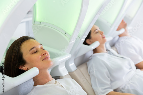 Male and female visitors of modern hair studio relaxing on massaging chairs before washing head
