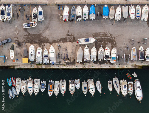 Docked boats in a marina, some in dry dock