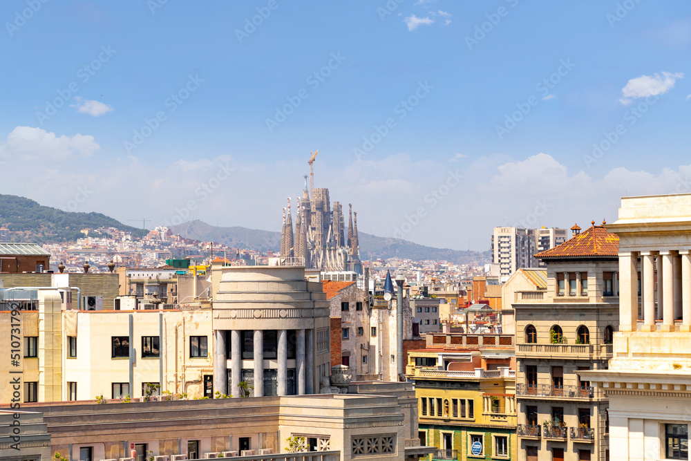 The Sagrada Familia Basilica seen from the rooftop of the Barcelona Cathedral on a summer day in the historic center of Barcelona, Spain.