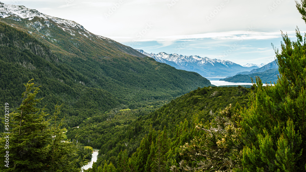 View from the top of a river going through a forest and flowing into a lake in the Andes mountain range. Calihuel River Rivadavia Lake. Chubut, Argentina