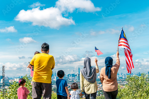 Photography Local people holding a Malaysian flag at the top of a hill