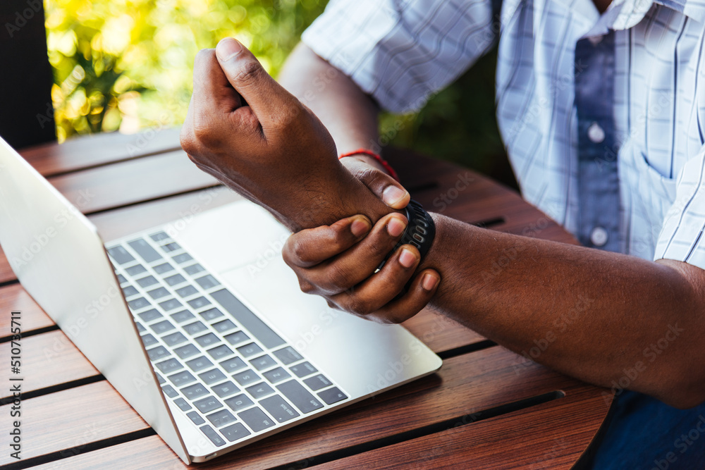 Foto de Closeup hands the Asian black man holding his wrist pain from ...