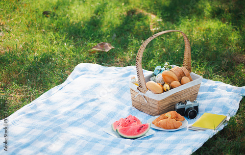 Photography Picnic wattled basket with bread food and fruit, Ukulele, a retro camera on blue