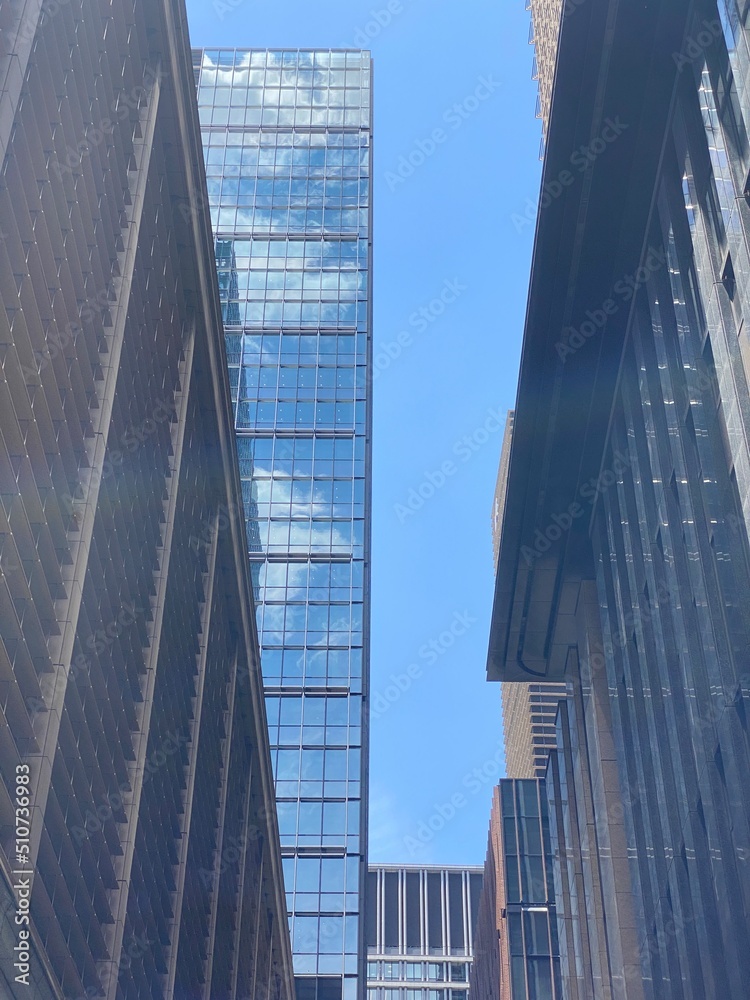 Looking up the sky between the city tower buildings, on a sunny weekday, central downtown Tokyo, year 2022 June 13th
