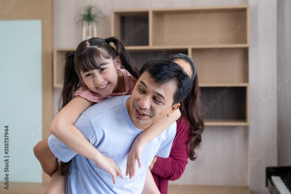 Happy child daughter sitting on father back piggybacking playing ...
