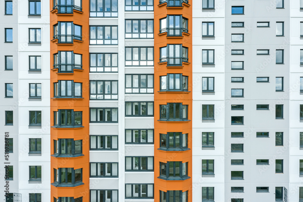 facade of a new modern high-rise apartment building with windows reflecting the sky facade of a new modern high-rise apartment building with windows reflecting the sky