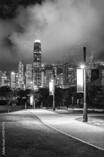 pedestrian walkway in park and skyline of Hong Kong city at night