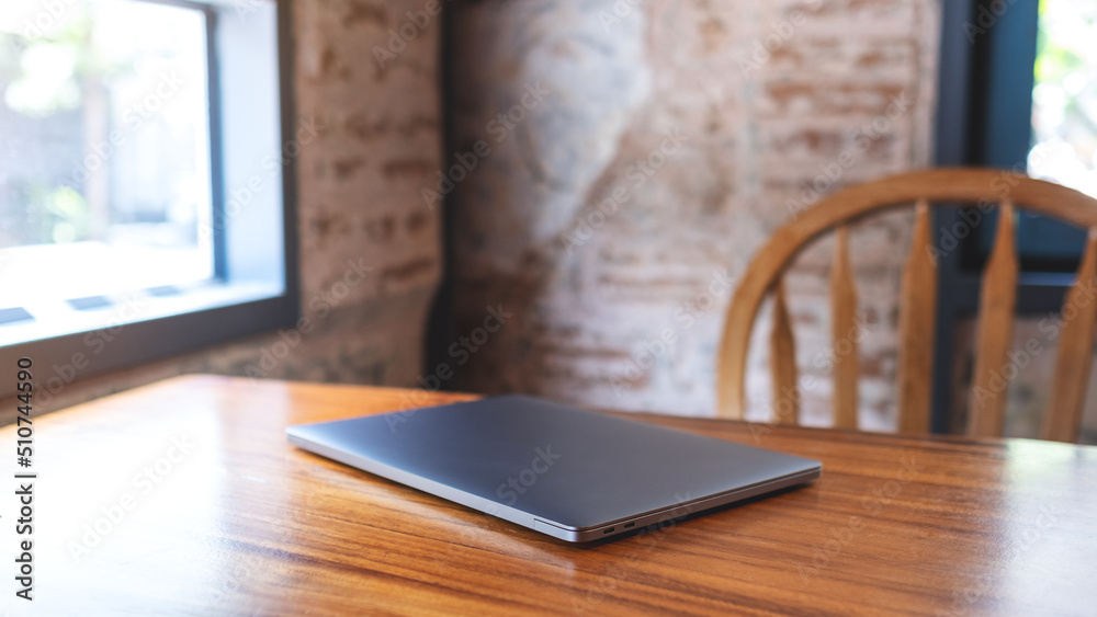 A single laptop computer on wooden table A single laptop computer on wooden table