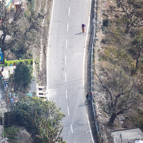 Aerial top view of traffic vehicles driving at mountains roads at Nainital, Uttarakhand, India, View from the top side of mountain for movement of traffic vehicles photo