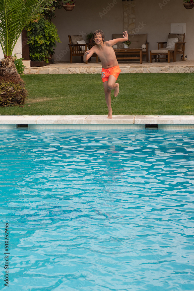 person in the pool. Blond boy with sunglasses diving into the pool