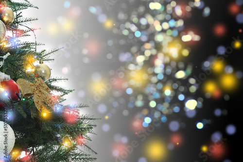 Beautiful Christmas tree with bright baubles against blurred lights on dark background, closeup. Space for text