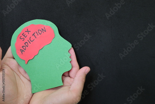 Obraz na płótnie Sex addiction treatment and how to deal with concept. Hand holding human head profile with sex addiction word on brain. w salonie