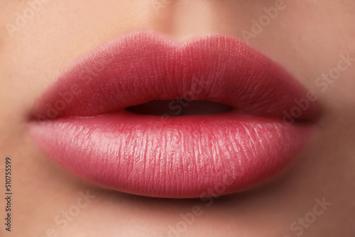 Woman with beautiful perfect lips after permanent makeup procedure, closeup