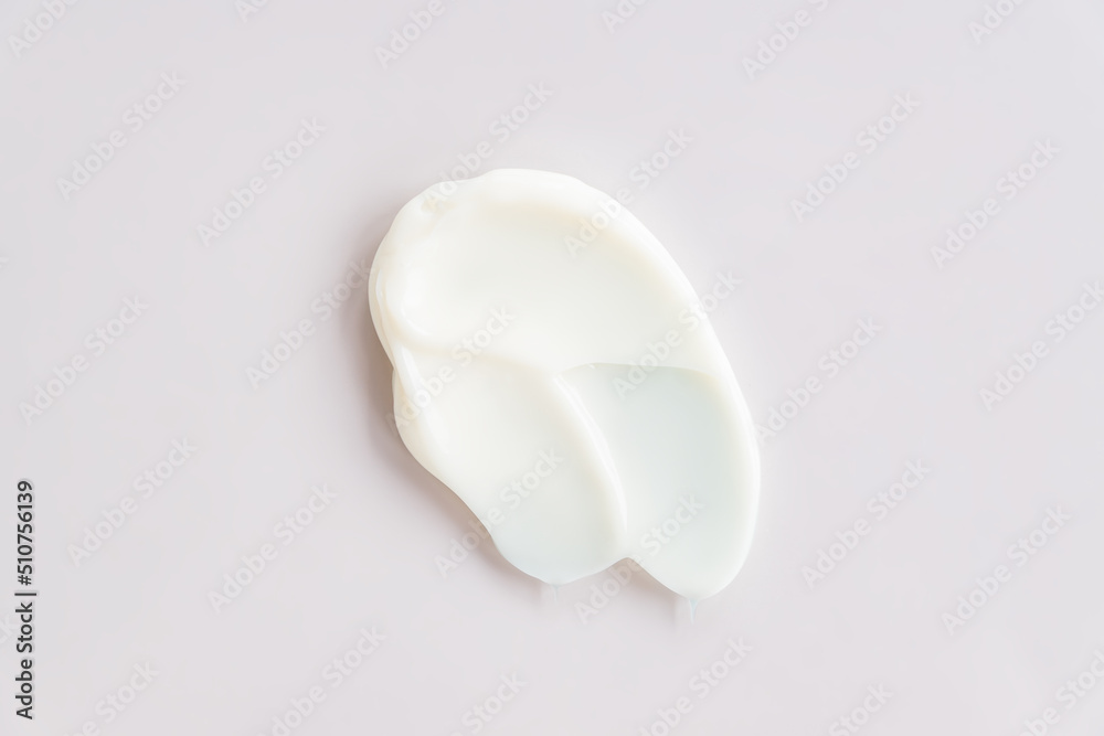 White cosmetic cream texture, skincare lotion swatch on pstel background. Face creme, body moisturiser, hair conditioner smear smudge stroke. Creamy beauty product closeup