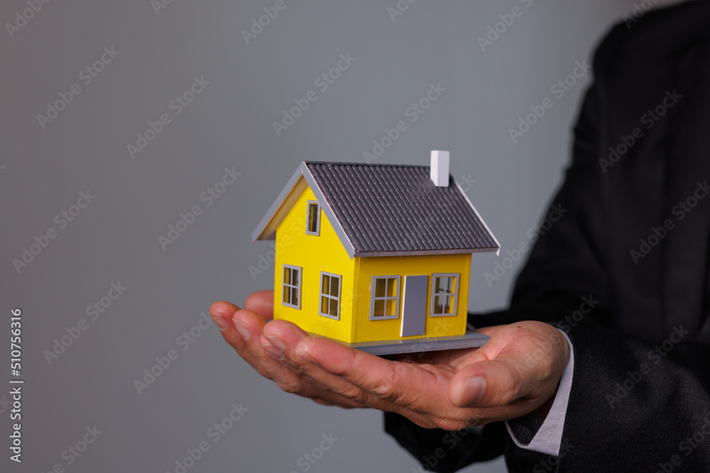 Businessman Hand holding home model, mortgage loan concept Businessman Hand holding home model, mortgage loan concept