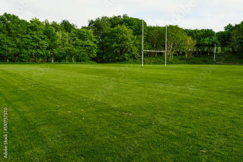 Green field with tall goal post for Irish National sport hurling and camogie in a park. Popular activity in Ireland for man, woman and children.