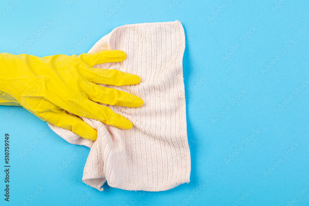 worker's hand in a yellow rubber protective glove with a pink-beige sponge or washcloth. A maid or housewife takes care of the house. general or regular cleaning. 