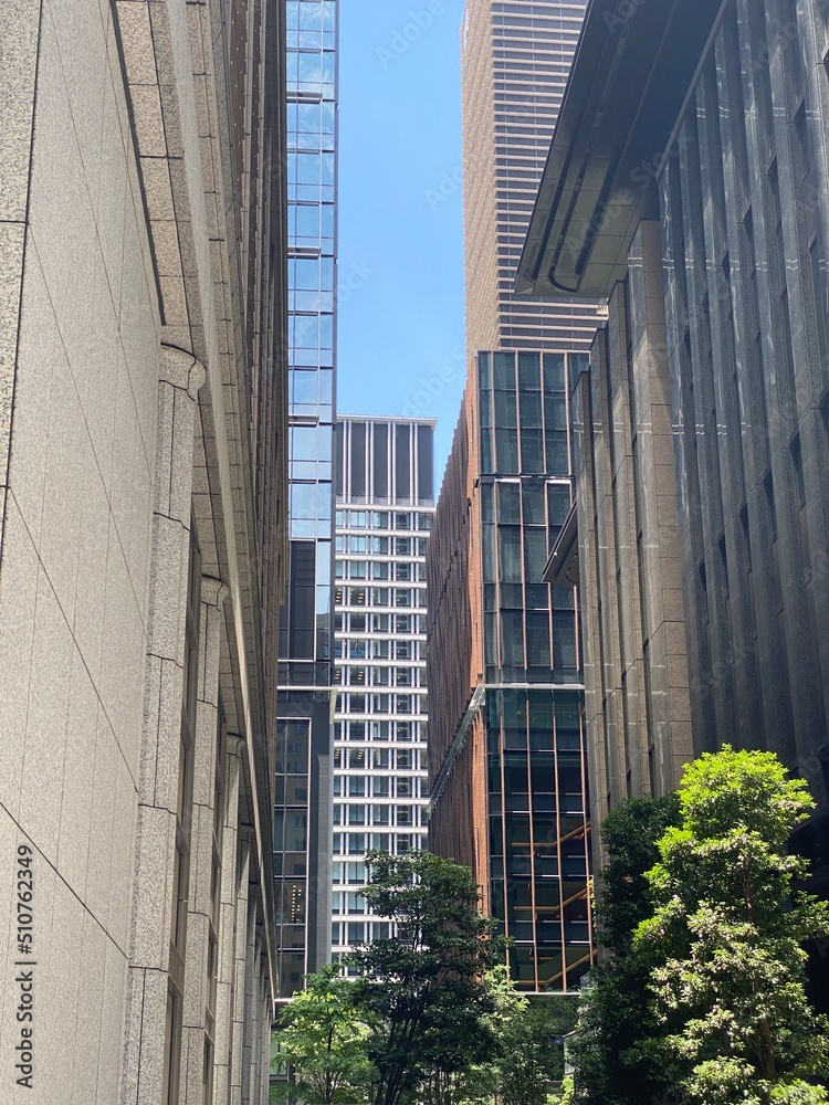 Obraz premium High-rise towers look from the ally at the central Tokyo Japan, Otemachi district, offices and restaurants, sunny weekday year 2022 June 13th