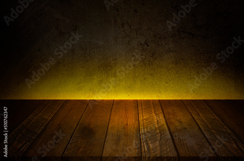 Old wood table with dark Concrete wall and Yellow lighting Effect background.